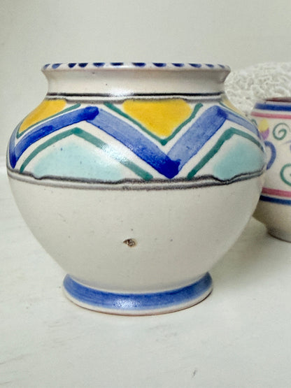 Pair of vintage studio pottery pots in blue green and pink glaze photographed on a white surface
