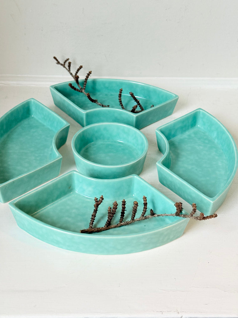 Poole Pottery turquoise hors d’oeuvre dishes set of five displayed on a white surface.