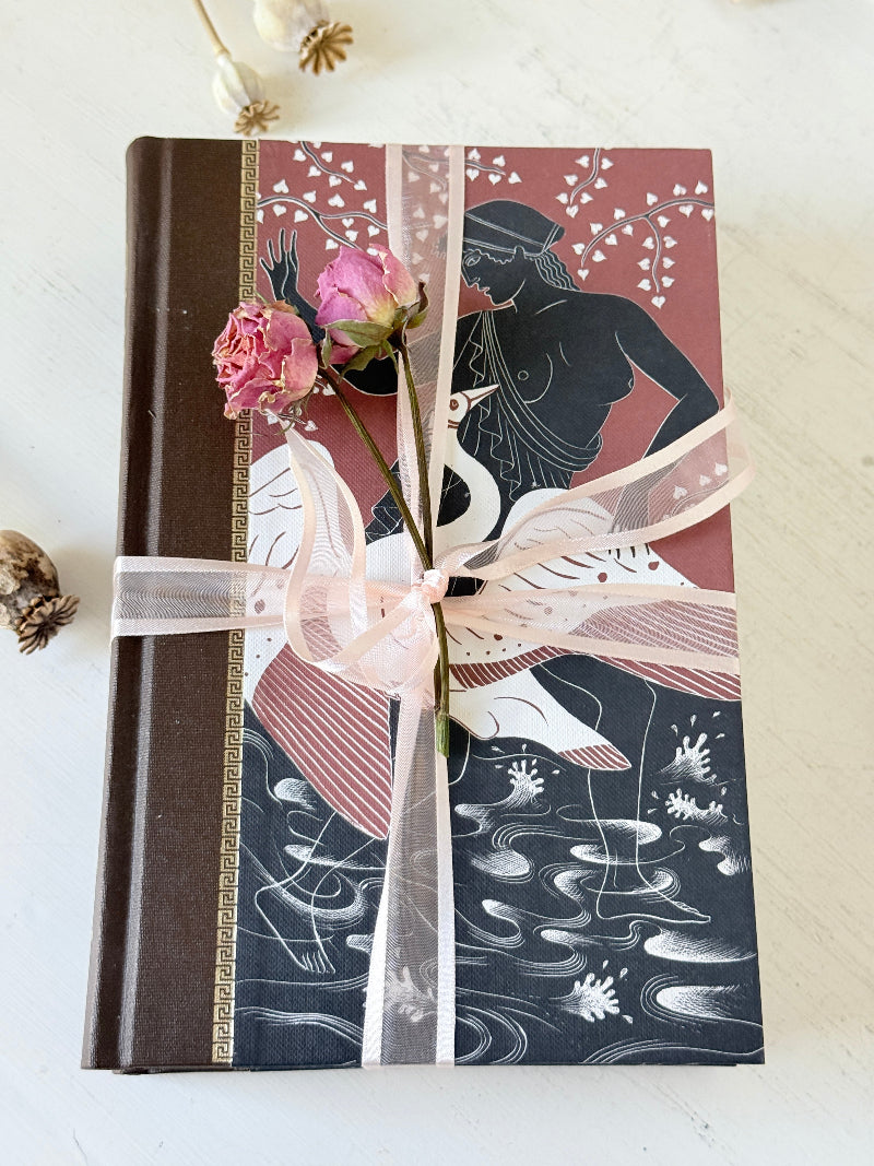 Pair of vintage Greek myths books with brown illustrated covers, pale pink ribbon and dried flower detail for shelf styling