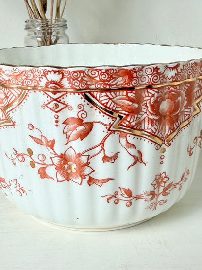 vintage porcelain sugar bowl with coral transfer design and gilt rim on white surface