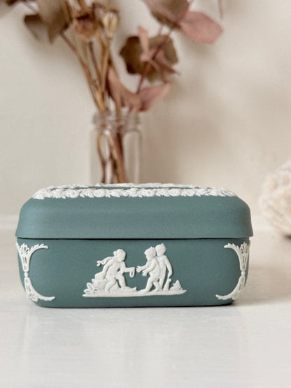 Vintage Wedgwood Jasperware teal green square lidded trinket box, decorated with white neoclassical figures and florets, styled with dried stems.