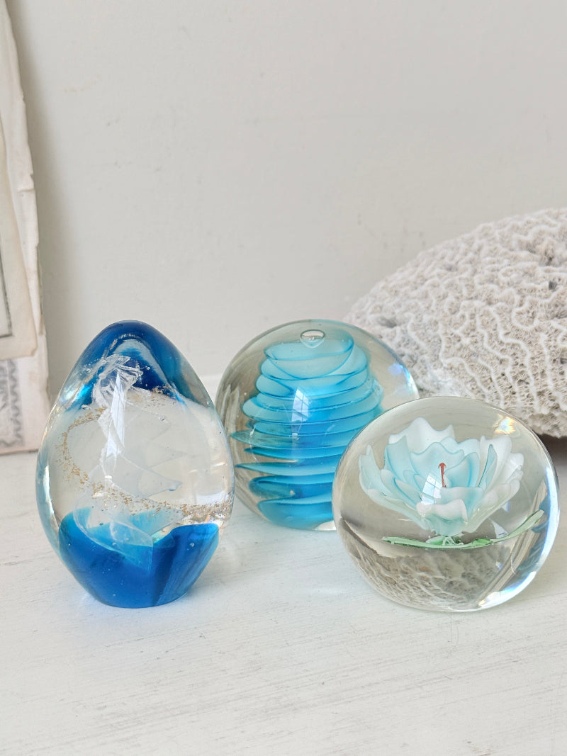 Trio of vintage turquoise blue glass paperweights with swirl, ribbed and floral detail in clear coloured glass