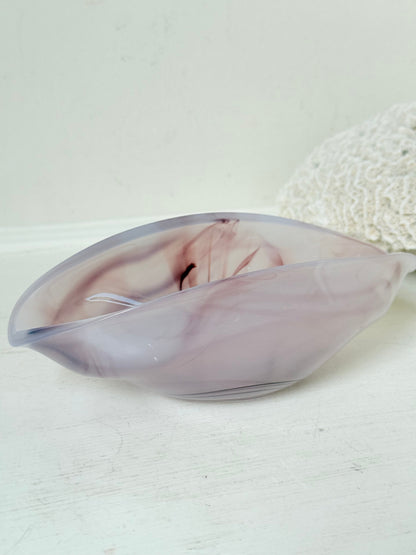 Vintage clam shaped Sowerby glass bowl in lilac purple swirl photographed on a white surface