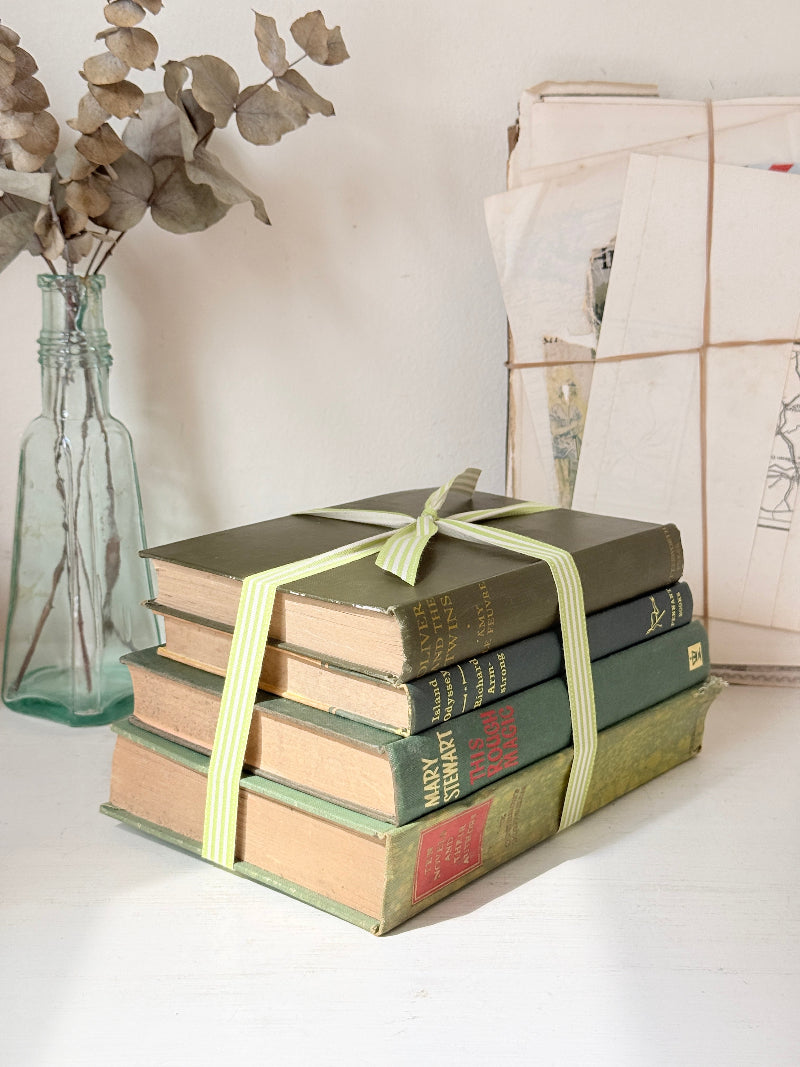 Bundle of vintage sage and olive green cloth books with red spine detail tied with a pale ribbon for styling
