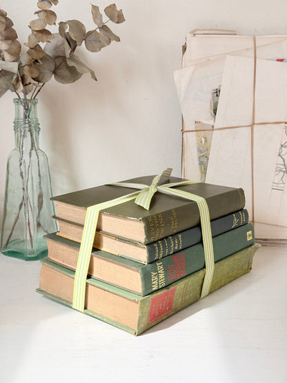 Bundle of vintage sage and olive green cloth books with red spine detail tied with a pale ribbon for styling