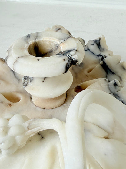 Antique alabaster marble floral candleholder with carved leaves and flowers, photographed on a white surface.