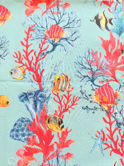 The Blue Loft coral reef cotton tea towels in turquoise and pale pink with coastal marine pattern photographed on a stone surface.