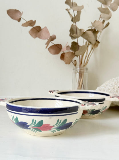 Pair of vintage French Quimper Breton figure snack bowls with painted side handles, photographed on a white surface