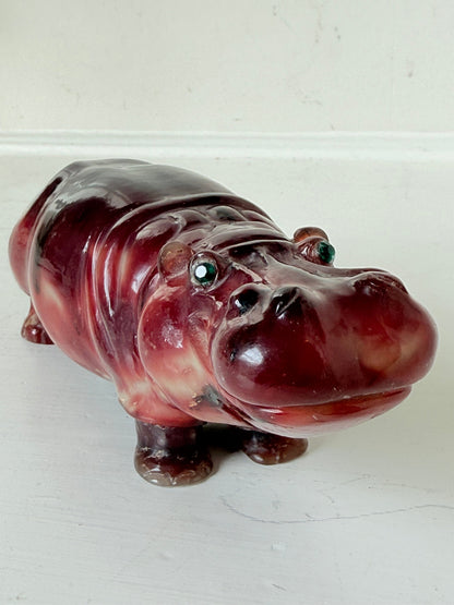 Red polished stone hippopotamus ornament displayed on a white background.