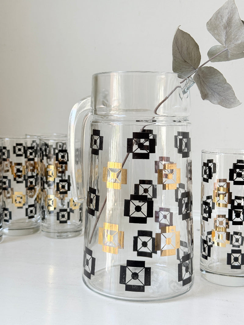 Mid century black and gold glass drinks set with jug and five highball tumblers in a geometric medallion pattern