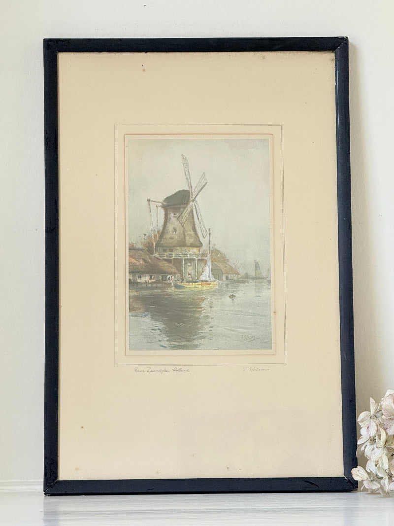 framed print of dutch windmill beside water in holland with reflection photographed on white surface