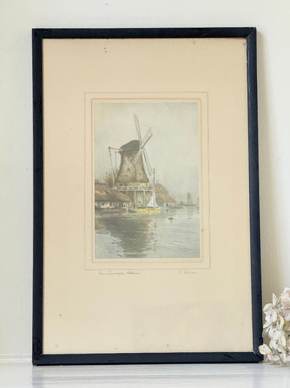 framed print of dutch windmill beside water in holland with reflection photographed on white surface