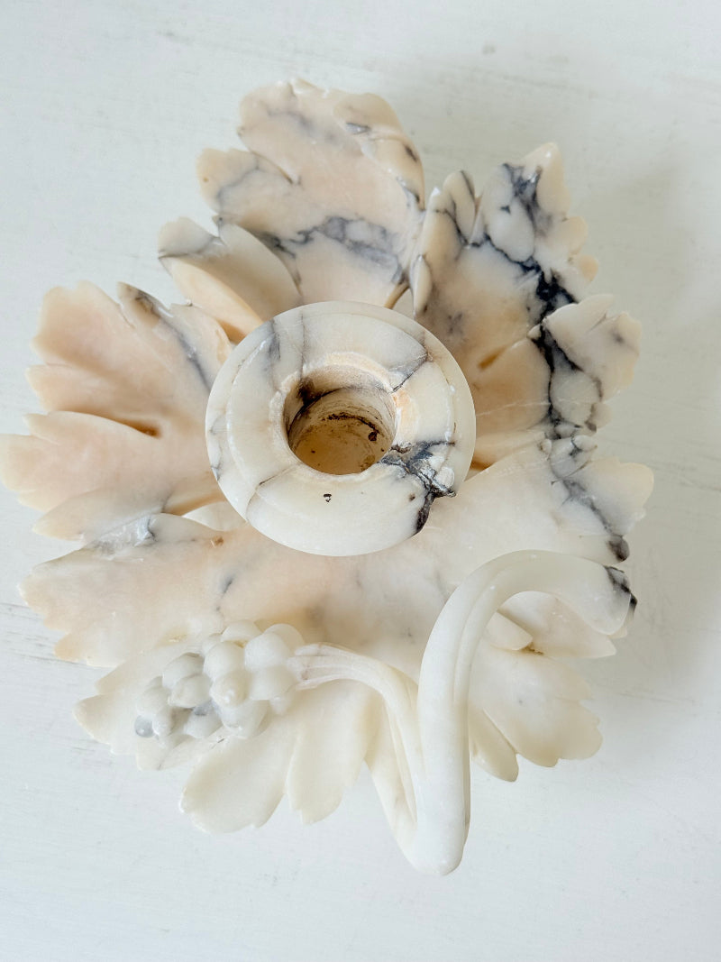 Antique alabaster marble floral candleholder with carved leaves and flowers, photographed on a white surface.