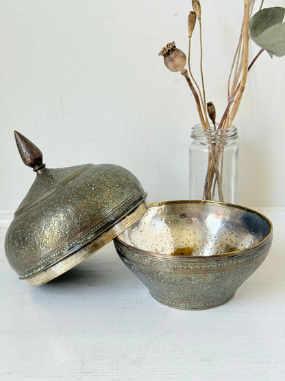 Indian Benares brass lidded jar with floral engraving and finial, photographed on a white surface