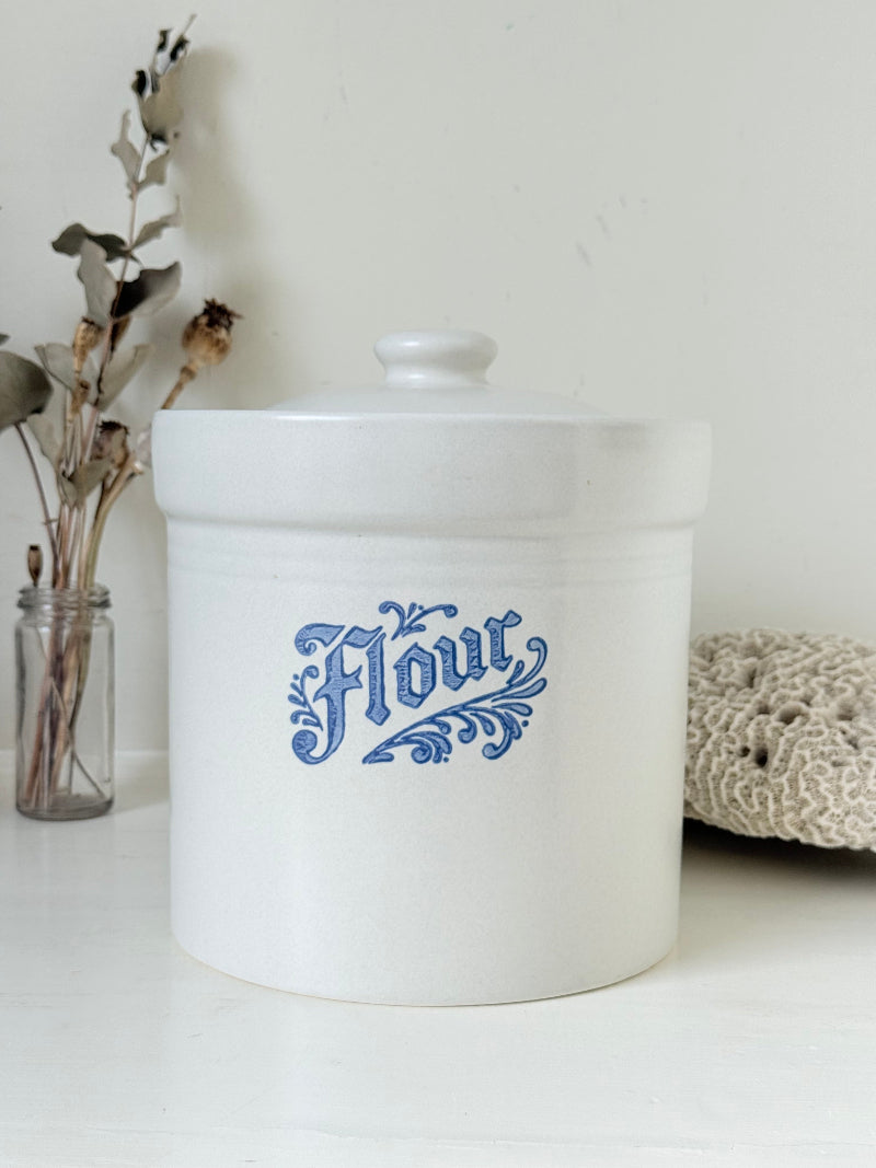 Pfaltzgraff Yorktowne stoneware flour pot with blue floral motif and lid, photographed on a white surface