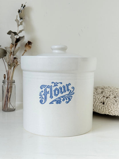 Pfaltzgraff Yorktowne stoneware flour pot with blue floral motif and lid, photographed on a white surface