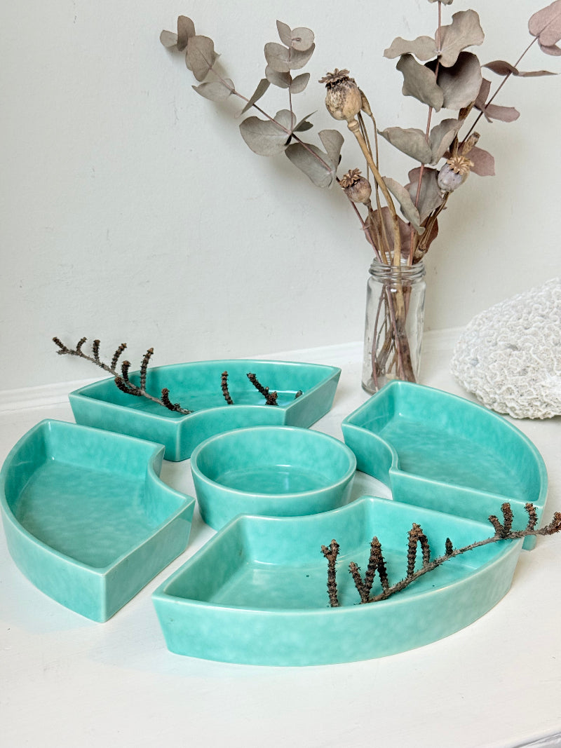 Poole Pottery turquoise hors d’oeuvre dishes set of five displayed on a white surface.