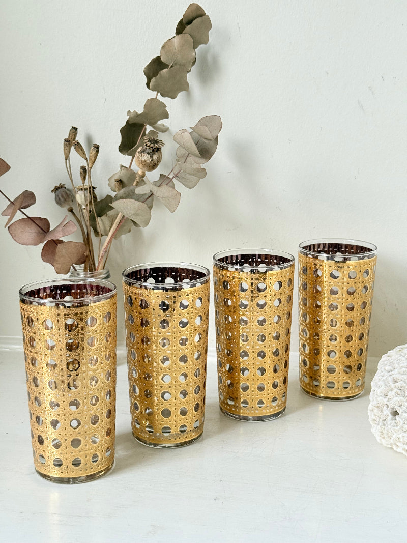 Set of 4 vintage gold rattan effect glasses with pierced lattice sleeves, photographed on a white surface