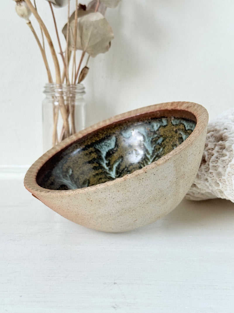 Benjamin Eeles studio pottery stoneware bowl with green and blue glazed interior on a white surface.