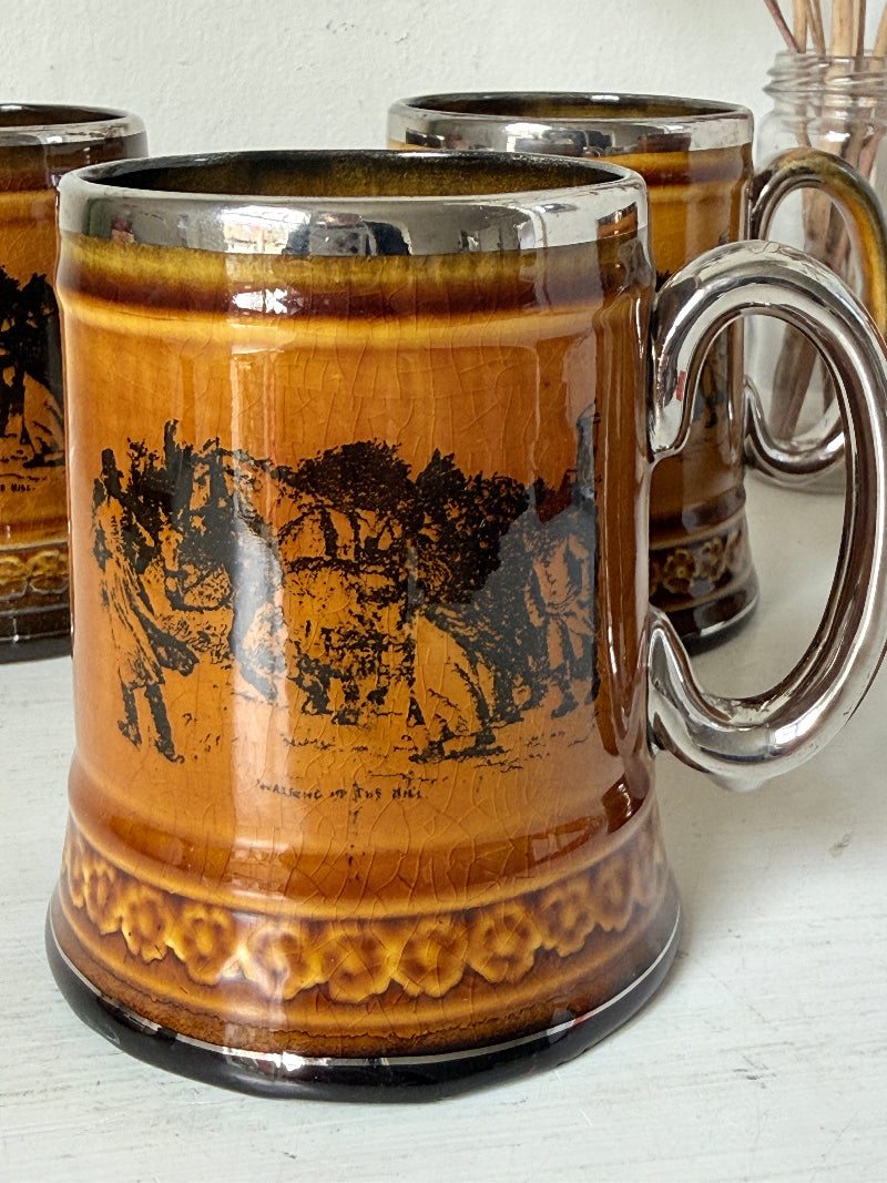 Set of 4 Ridgways stoneware tankard mugs photographed on a white surface in amber brown treacle glaze with black Coaching Days and Coaching Ways transfer scenes