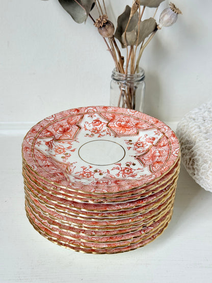 Set of 12 vintage coral transferware porcelain plates with scalloped edges and gold accents, 15 cm diameter, styled on a white surface.