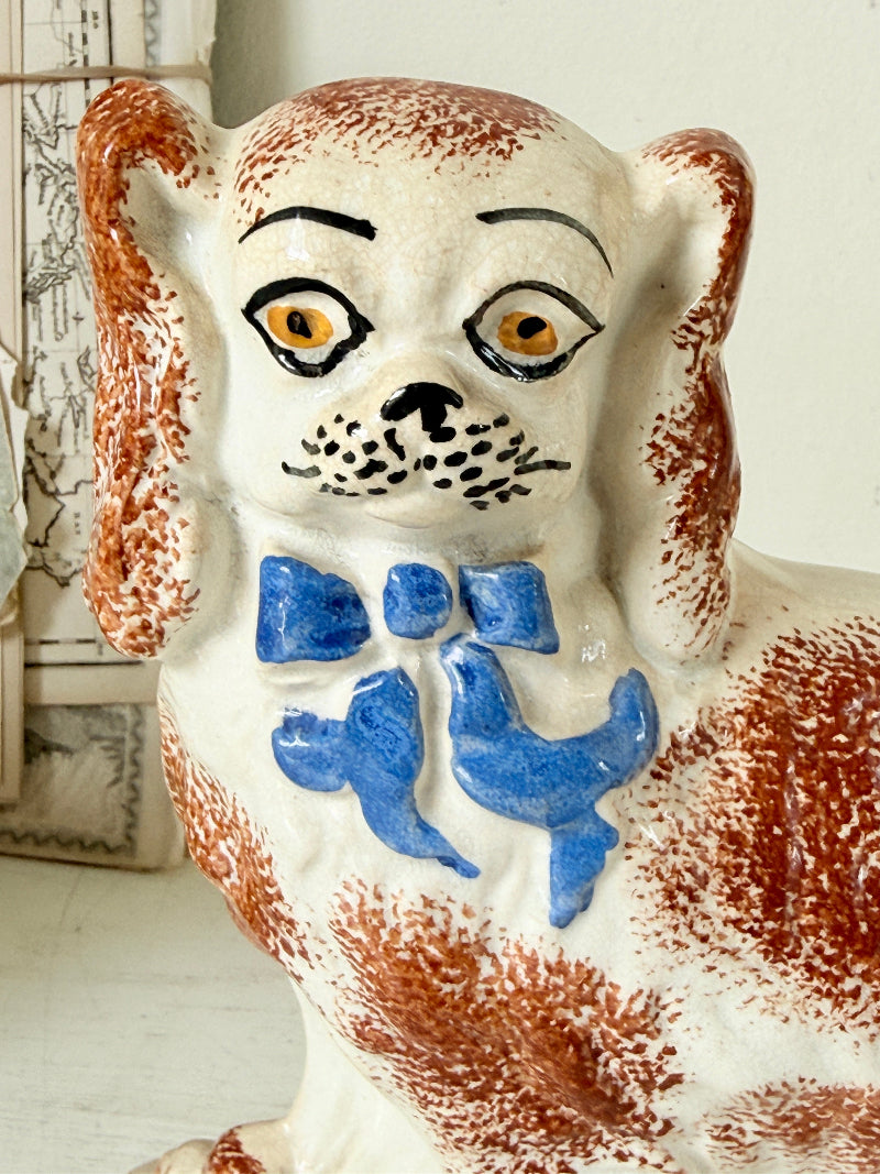 Pair of antique standing Staffordshire Pekingese dogs in rust red and white with blue painted bows