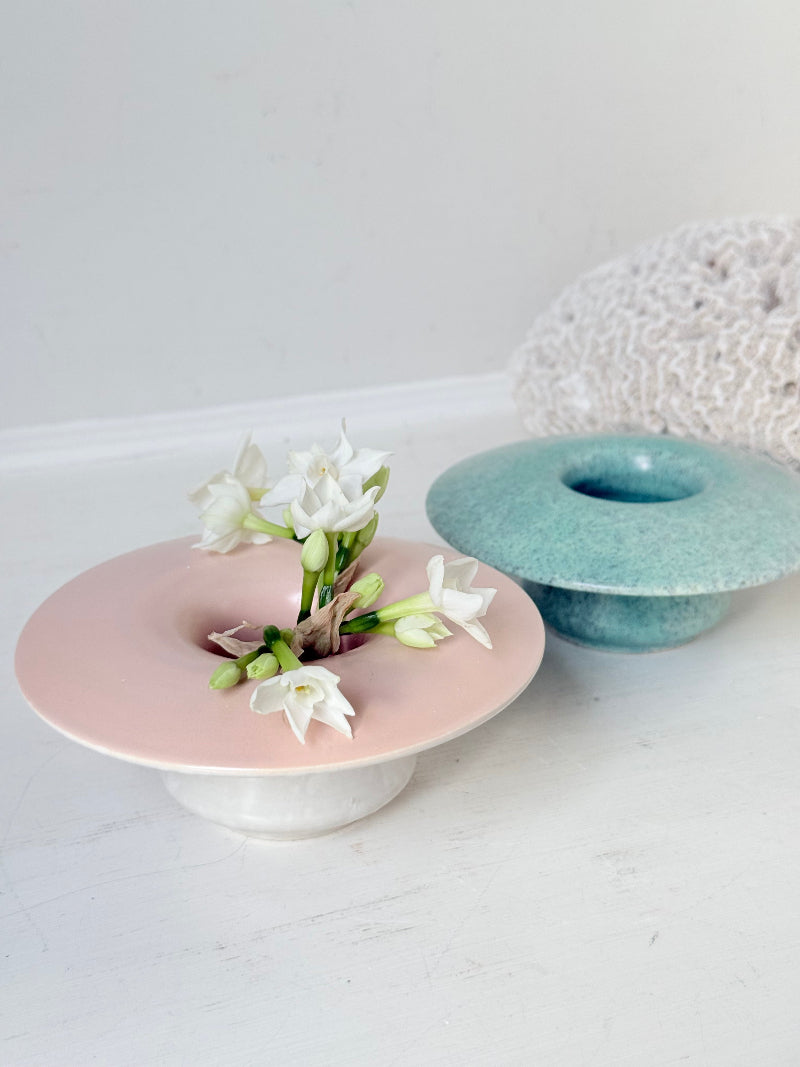 Pair of Poole Pottery mushroom posy vases in seafoam green and blush pink glazes photographed on a white surface