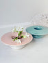 Pair of Poole Pottery mushroom posy vases in seafoam green and blush pink glazes photographed on a white surface