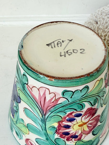 Italian handmade pot with colourful floral decoration, glazed finish, marked base, photographed on white surface.