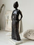 Solid bronze figure of a standing semi nude woman with upswept hair on a white marble base