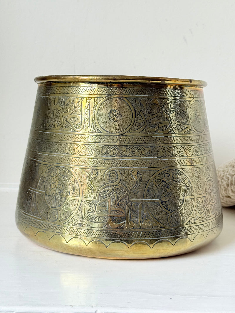 Large vintage brass pot with engraved decoration and aged patina, photographed on a white surface