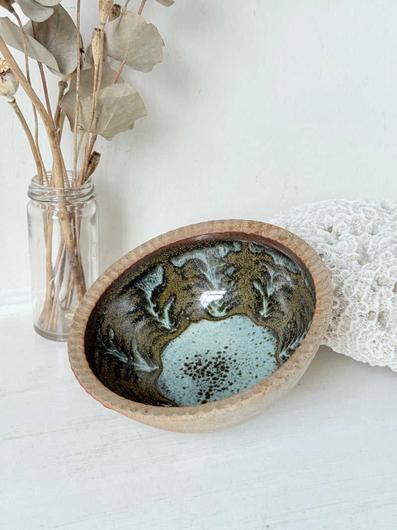 Benjamin Eeles studio pottery stoneware bowl with green and blue glazed interior on a white surface.