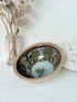 Benjamin Eeles studio pottery stoneware bowl with green and blue glazed interior on a white surface.