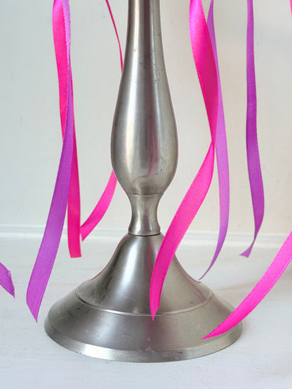 Five arm pewter style metal candelabra with aged silver finish styled with blue green taper candles on white surface
