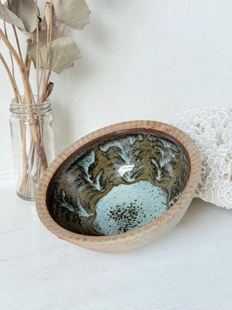 Benjamin Eeles studio pottery stoneware bowl with green and blue glazed interior on a white surface.