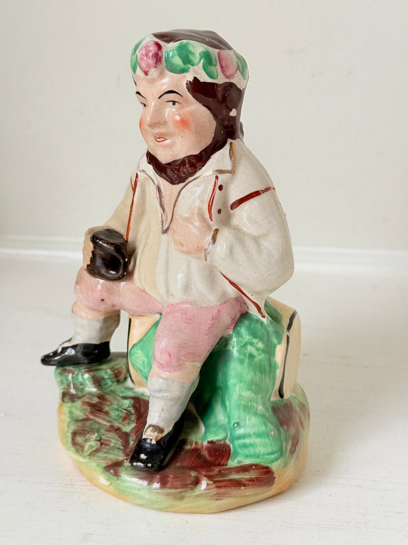 Bacchus antique Staffordshire pottery figure with painted details, photographed on a white surface.