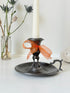 Vintage pewter chamberstick with handle and circular tray, photographed on a white surface