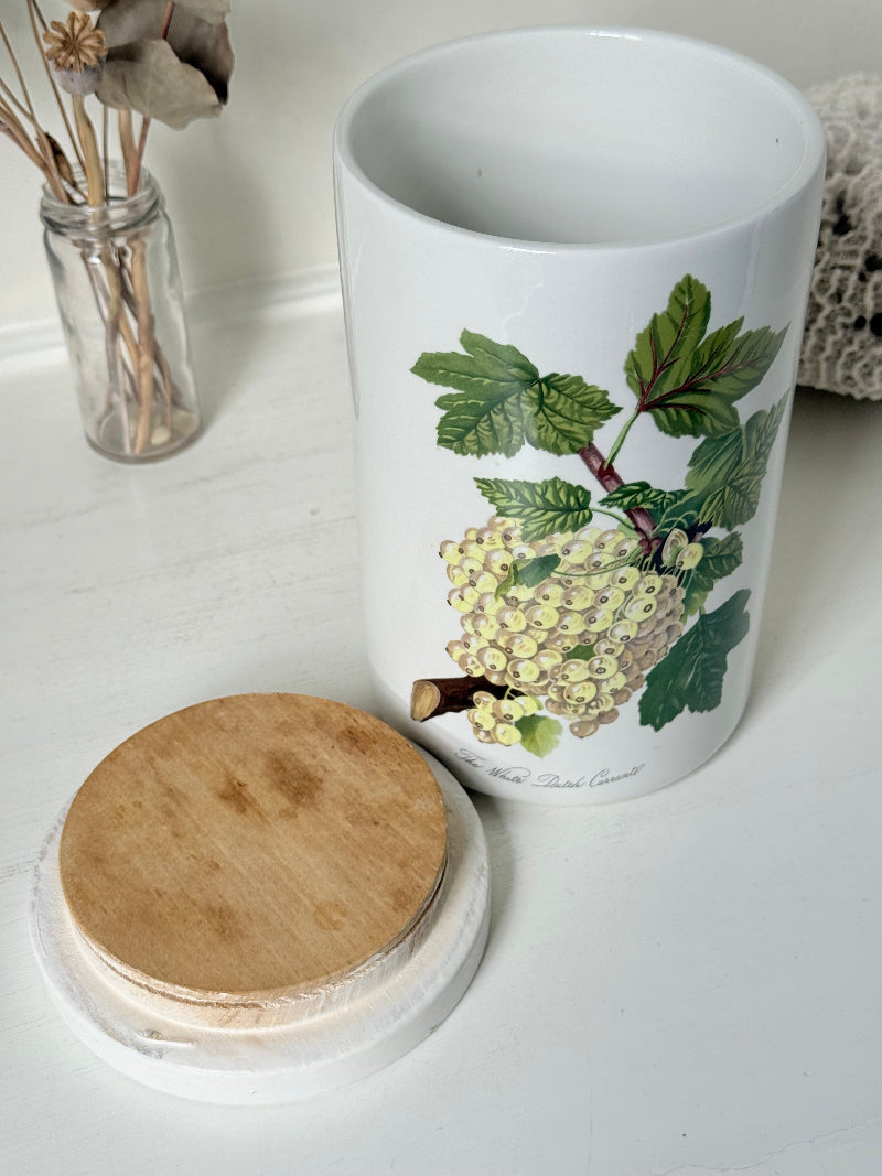 Vintage Portmeirion Botanic Garden ceramic canister with wooden lid and hydrangea design photographed on a white surface.