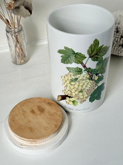 Vintage Portmeirion Botanic Garden ceramic canister with wooden lid and hydrangea design photographed on a white surface.