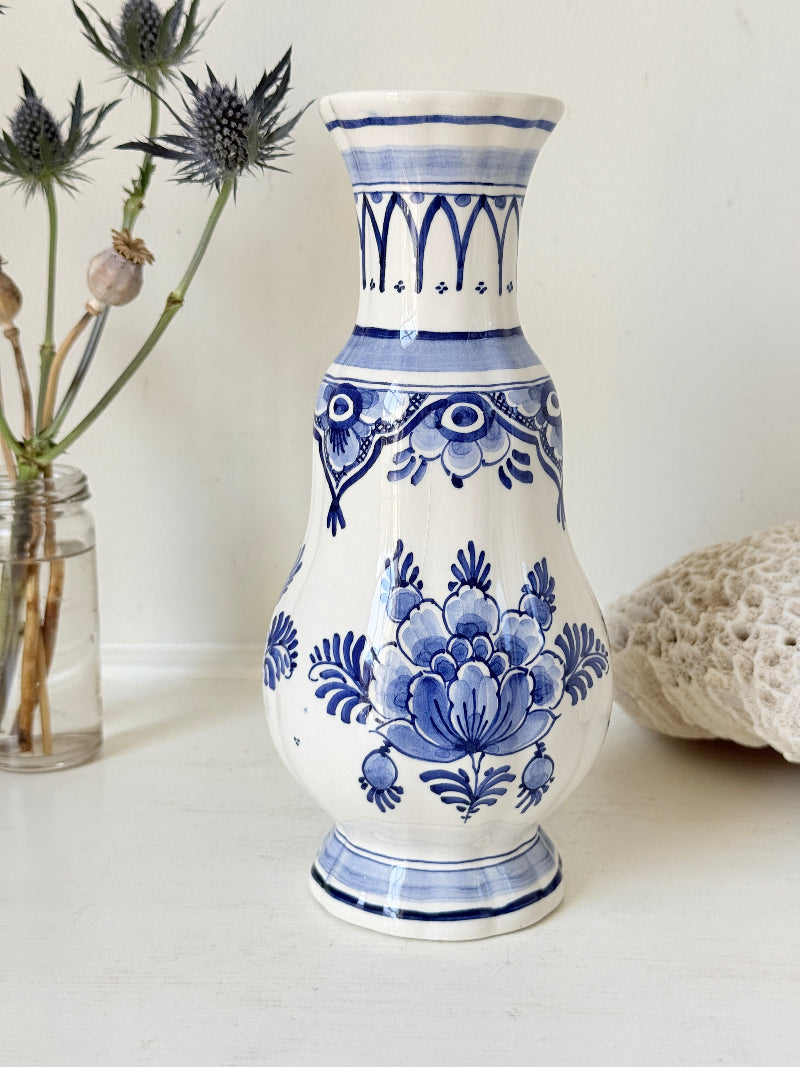 Vintage Delft style blue and white pottery vase with hand painted floral decoration, photographed on a white surface