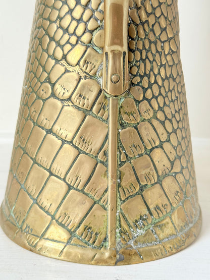 Vintage brass jug with alligator patterned surface, photographed against a white background.