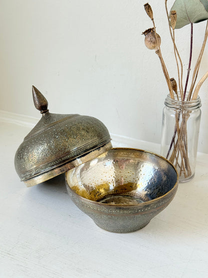 Indian Benares brass lidded jar with floral engraving and finial, photographed on a white surface