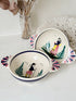 Pair of vintage French Quimper Breton figure snack bowls with painted side handles, photographed on a white surface