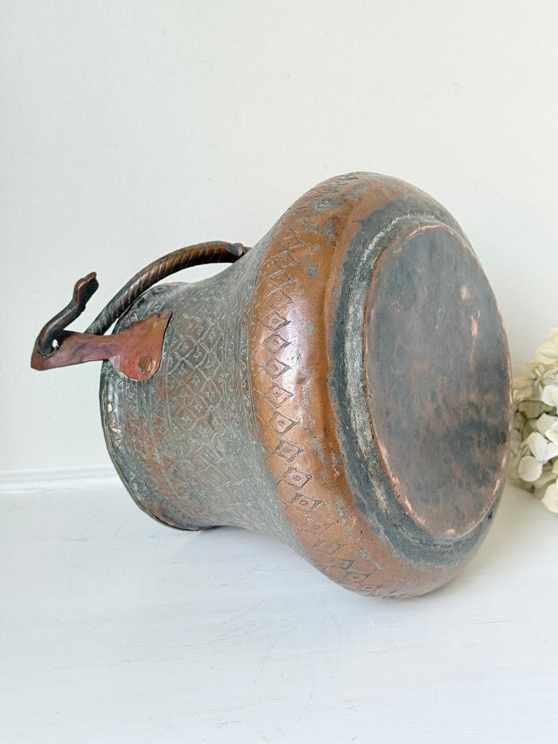 antique Middle Eastern water ewer with engraved diamond and foliate pattern and copper base, displayed on white surface
