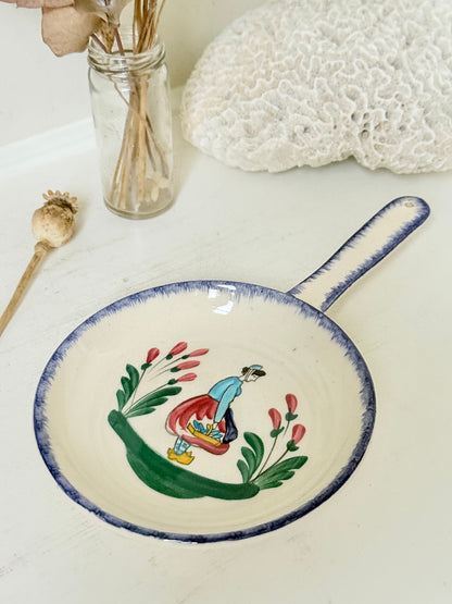 French Quimper faience handled wall dish with Petit Breton figure and blue rim, photographed on a white surface