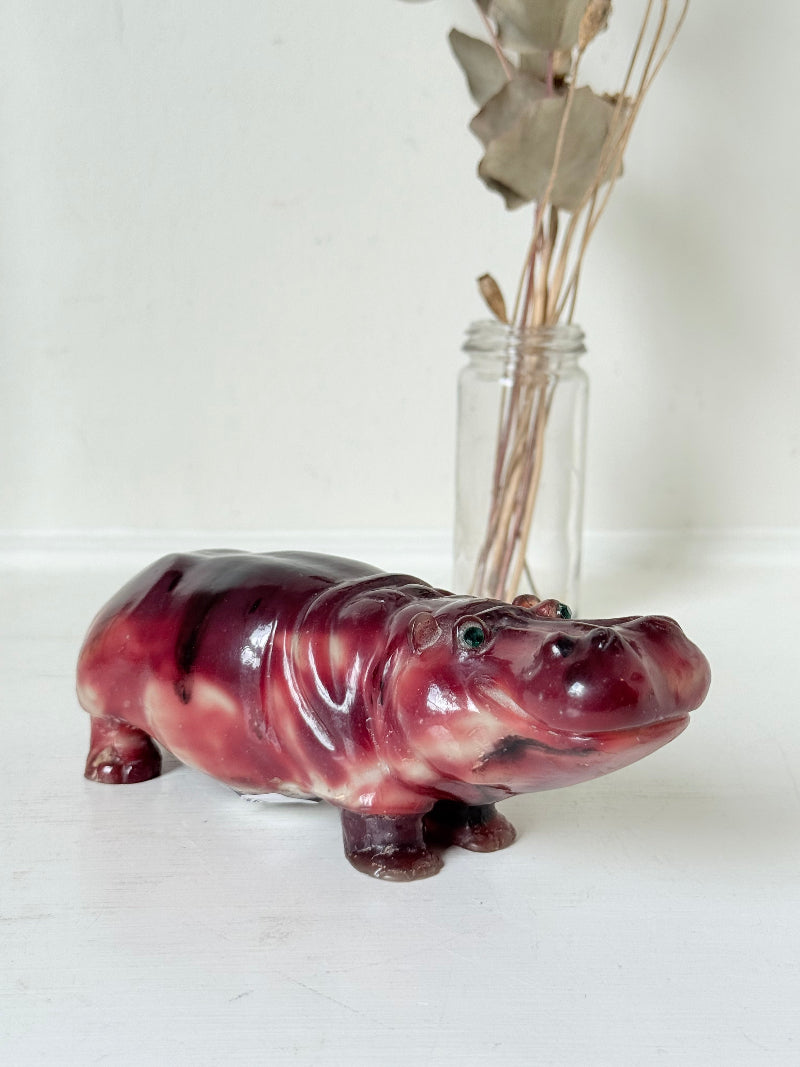 Red polished stone hippopotamus ornament displayed on a white background.