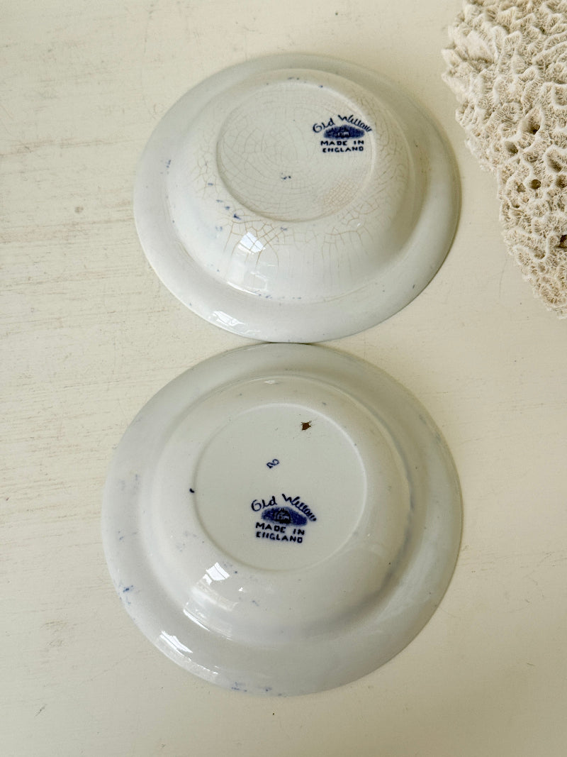 Pair of vintage blue and white Blue Willow snack bowls with patterned border photographed on a white surface