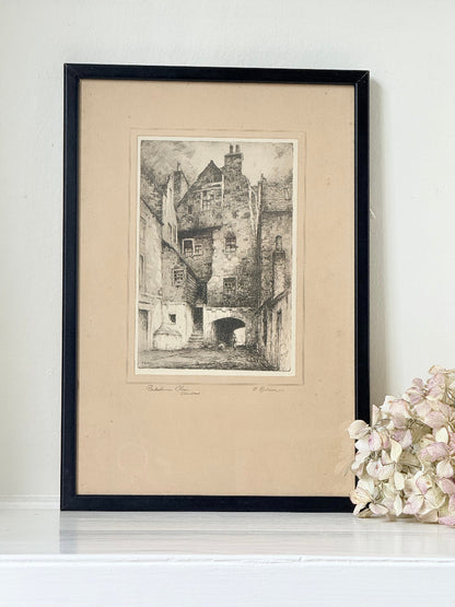 framed black and white print of edinburgh old town architecture photographed on white surface
