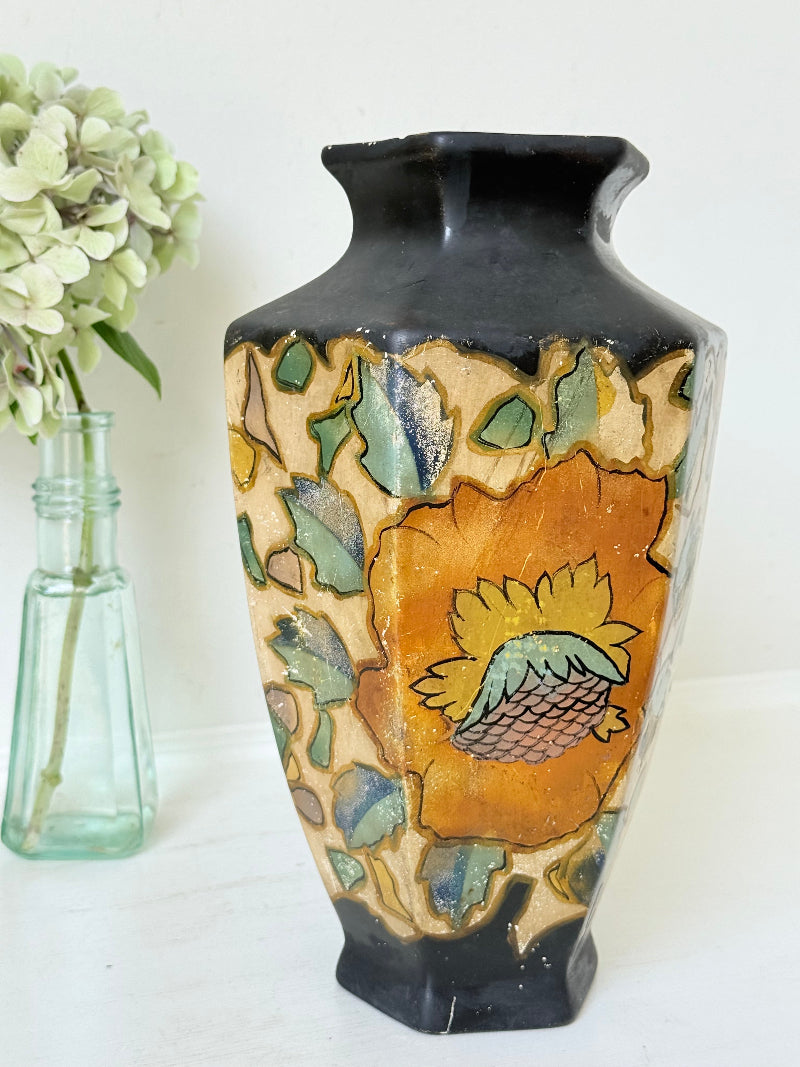 Art Deco Brentleigh Ware vase with hand painted floral design in orange, yellow, and teal on a black ground, photographed on a white surface