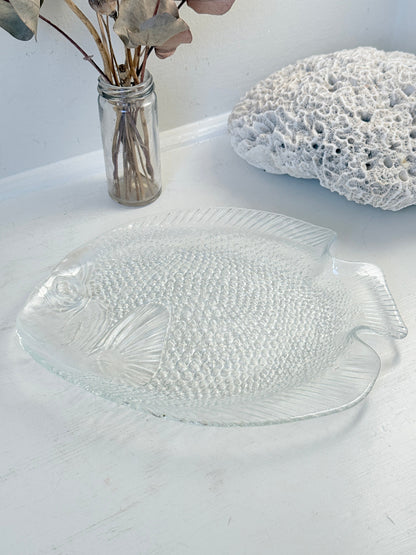 Vintage clear glass fish shaped serving dish with textured scale pattern photographed on a white surface